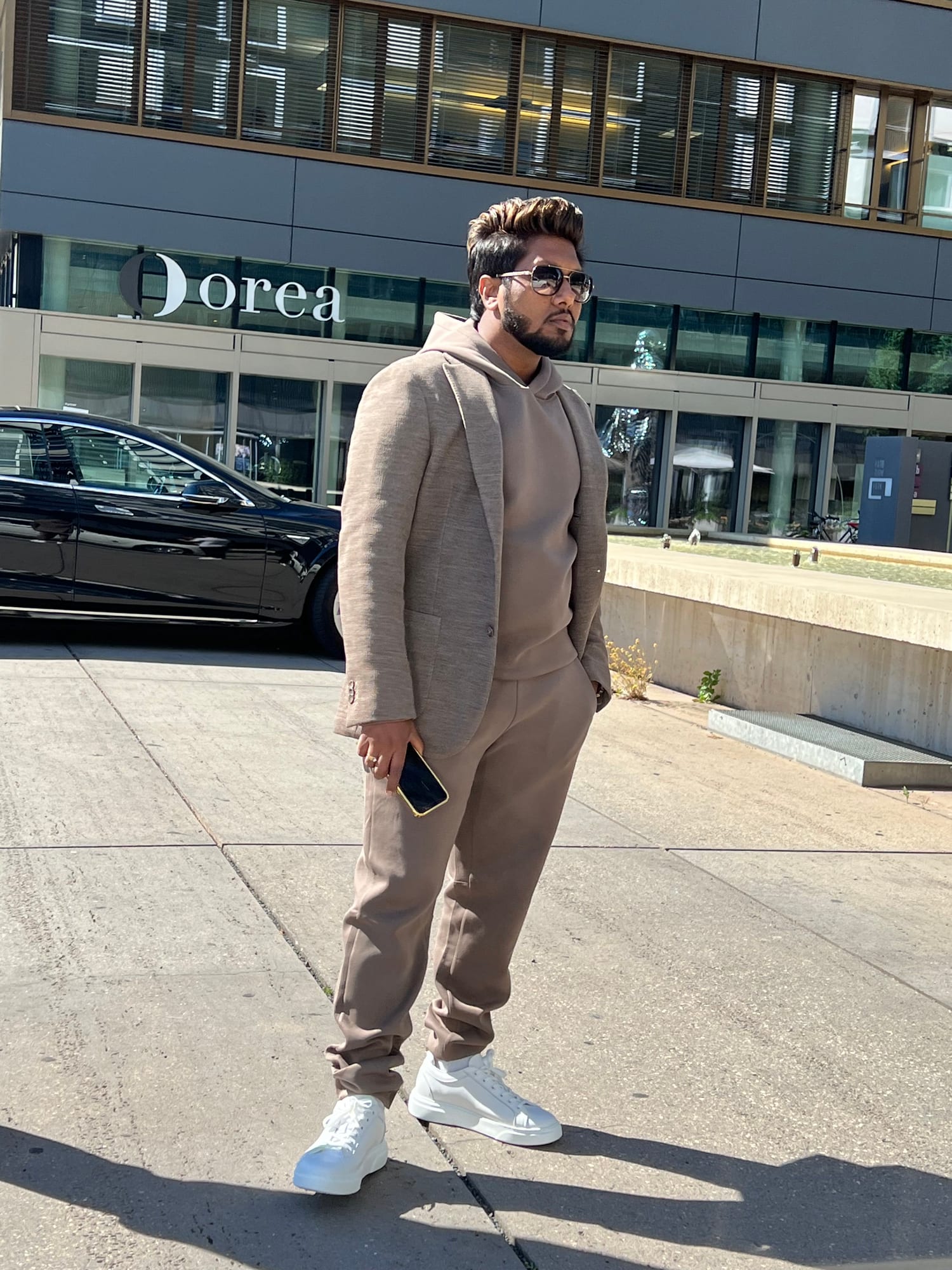 Vinay Anuragh in a tonal beige hoodie and blazer with aviator sunglasses